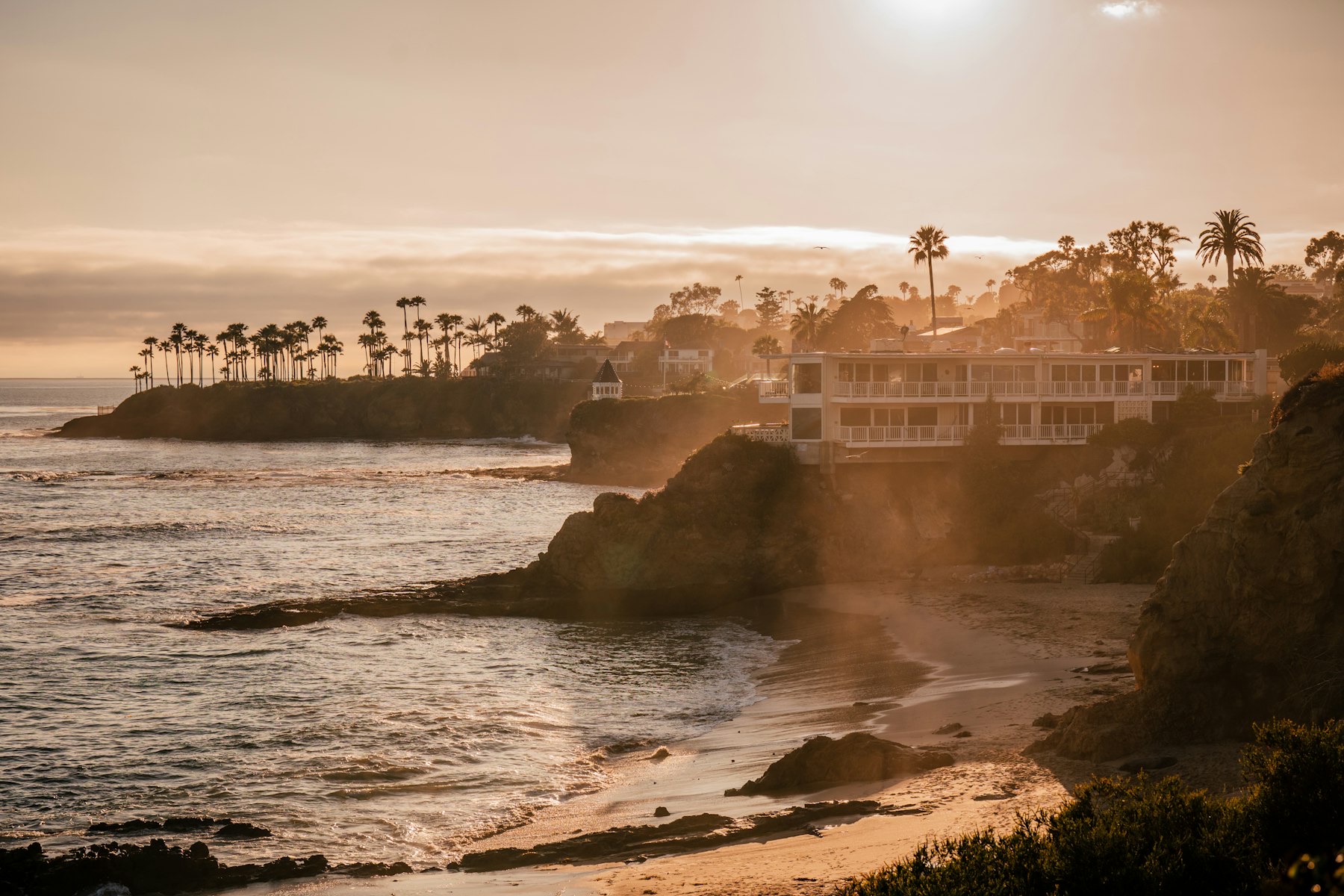 Cliffside hotel above a cove on the California coast at sunset